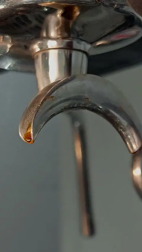 Espresso makinesinin ağzından süzülen koyu espresso